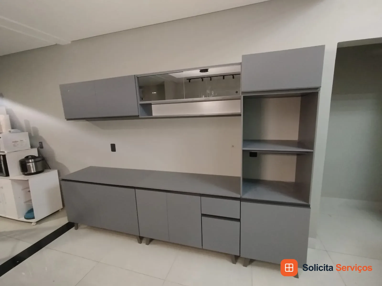 Conjunto de armários cinza com módulos superiores, portas, gavetas e nichos. As peças e suas funções devem ser conferidas conforme o modelo.
