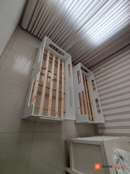 Estrutura de cama clara com estrado e ripas de apoio.