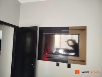 Painel de duas cores com televisão instalada.