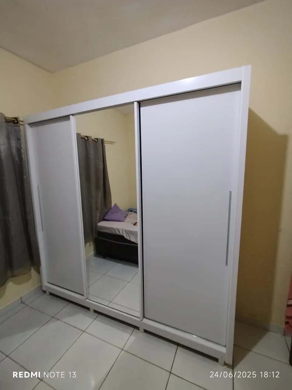 Fotografia do acervo com guarda-roupa branco de portas de correr.